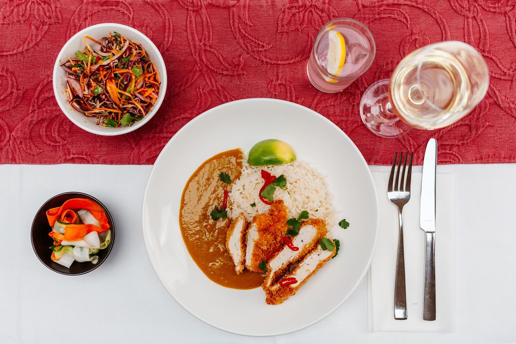 an aerial view of a table setting featuring Katsu curry with Asian slaw