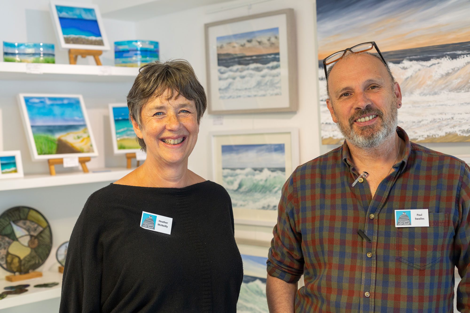 Paul Swailes & Heather McNeilly, two co-founders of The Pier Gallery stood in front of artwork in the gallery