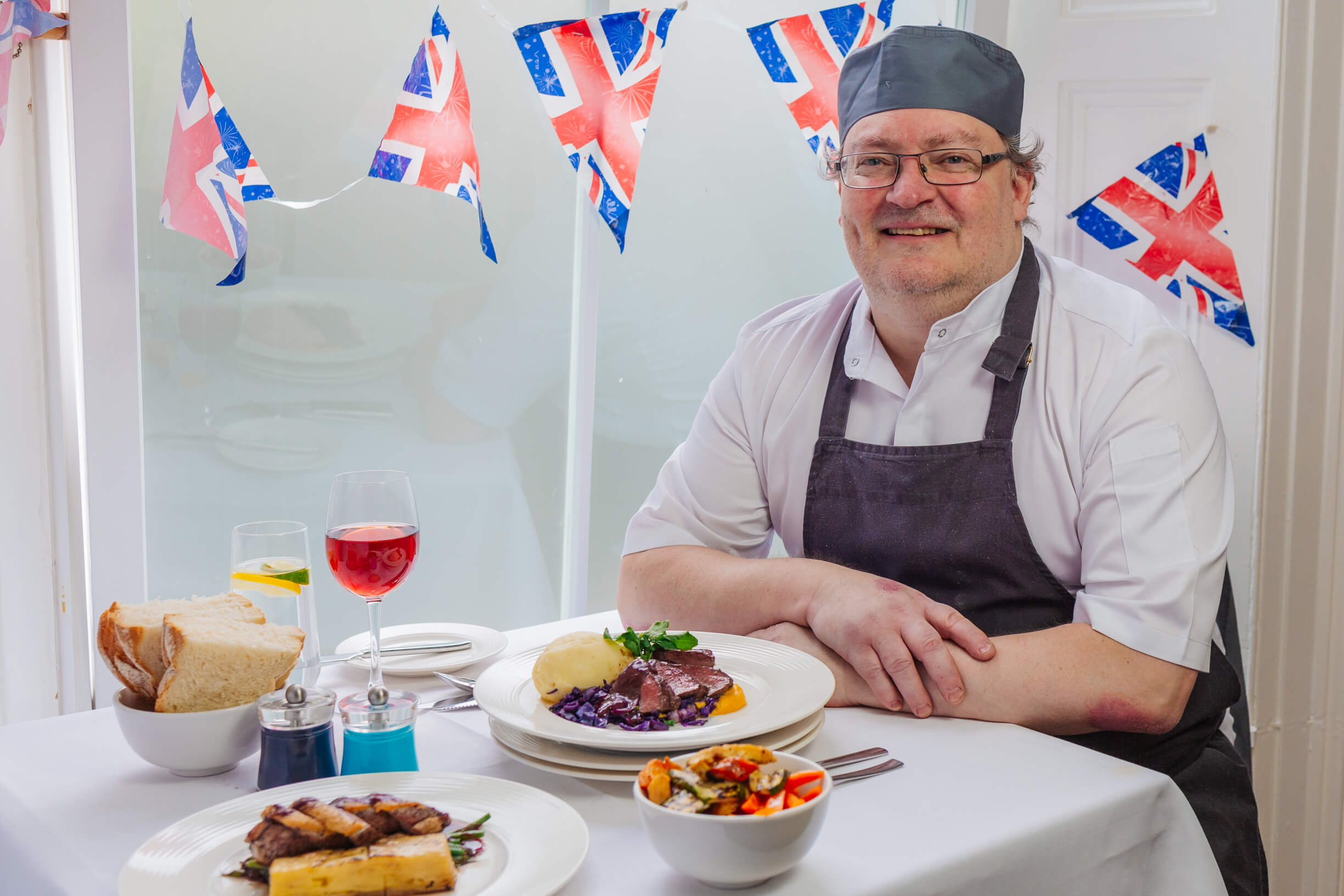 Eliot Seabourn-Wren of The Carlton Hotel sits at a table ready to enjoy a meal using British ingredients